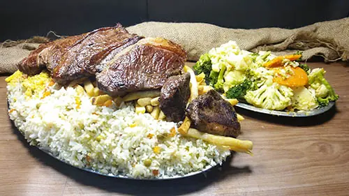 Carne grelhada com arroz e legumes na travessa